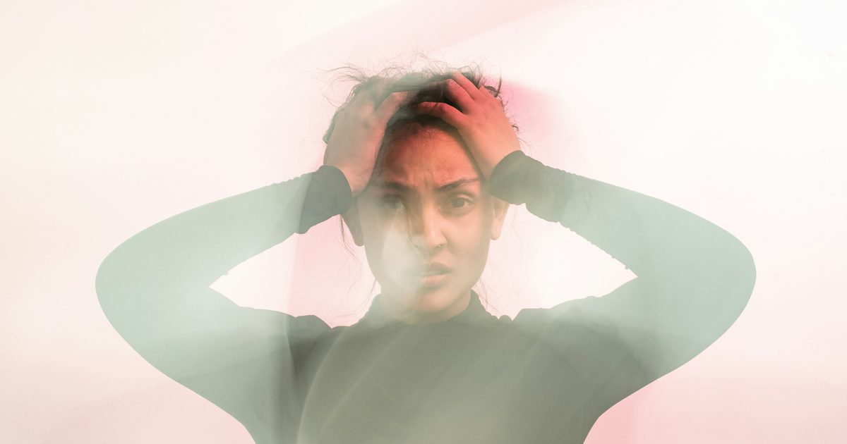Frustrated female entrepreneur holding her head in front of a DIY website showing common website mistakes